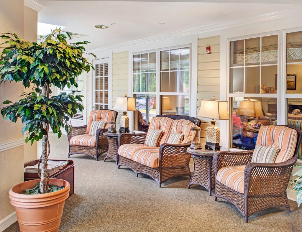 A cozy indoor seating area with wicker furniture and plants.