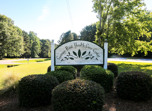 A welcoming sign for an outdoor community area, surrounded by lush greenery.