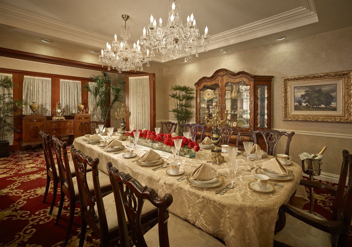 An elegantly decorated dining room with a chandelier and a beautifully set table.