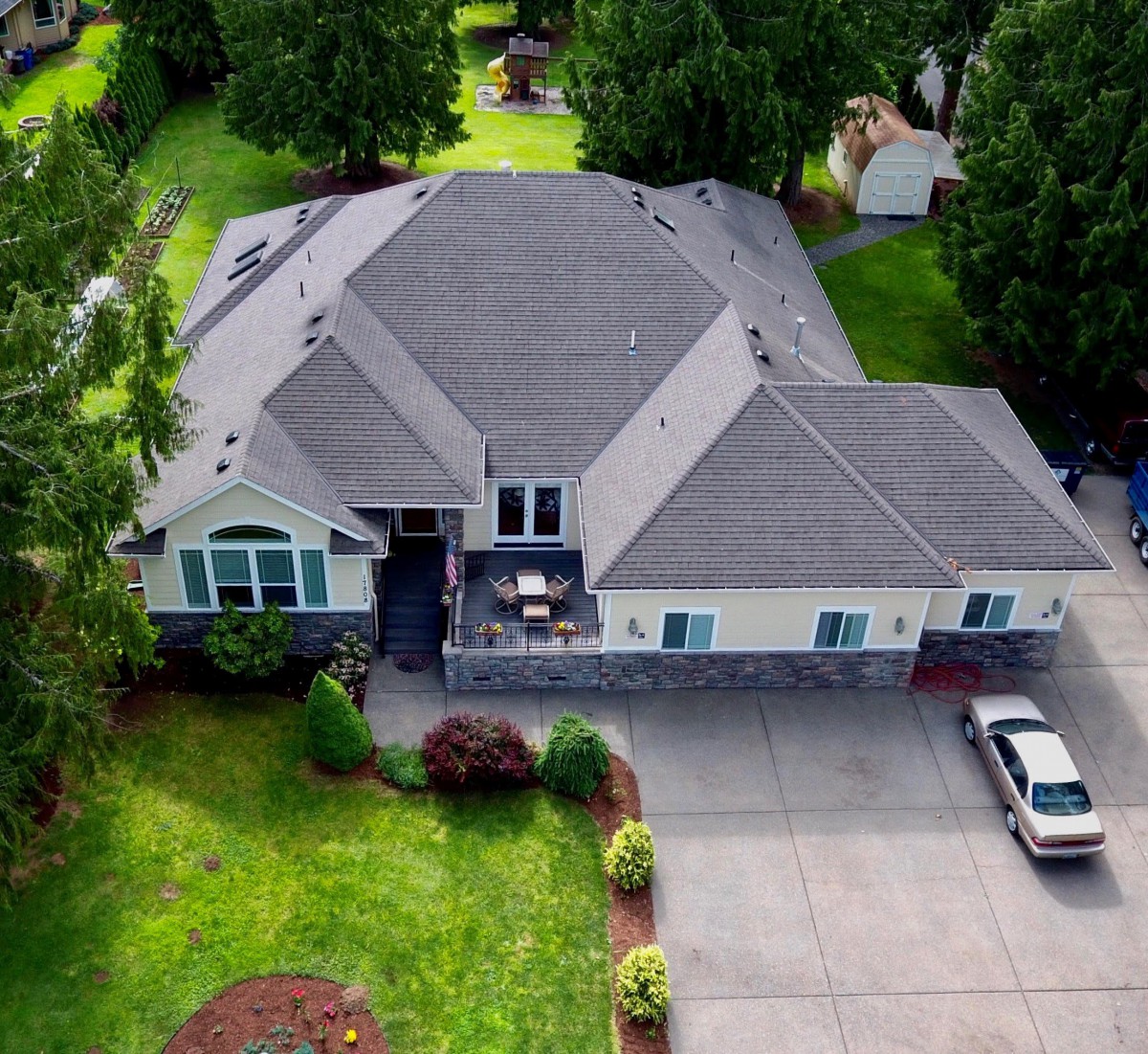 Aerial view of a spacious house with a well-maintained lawn and driveway.
