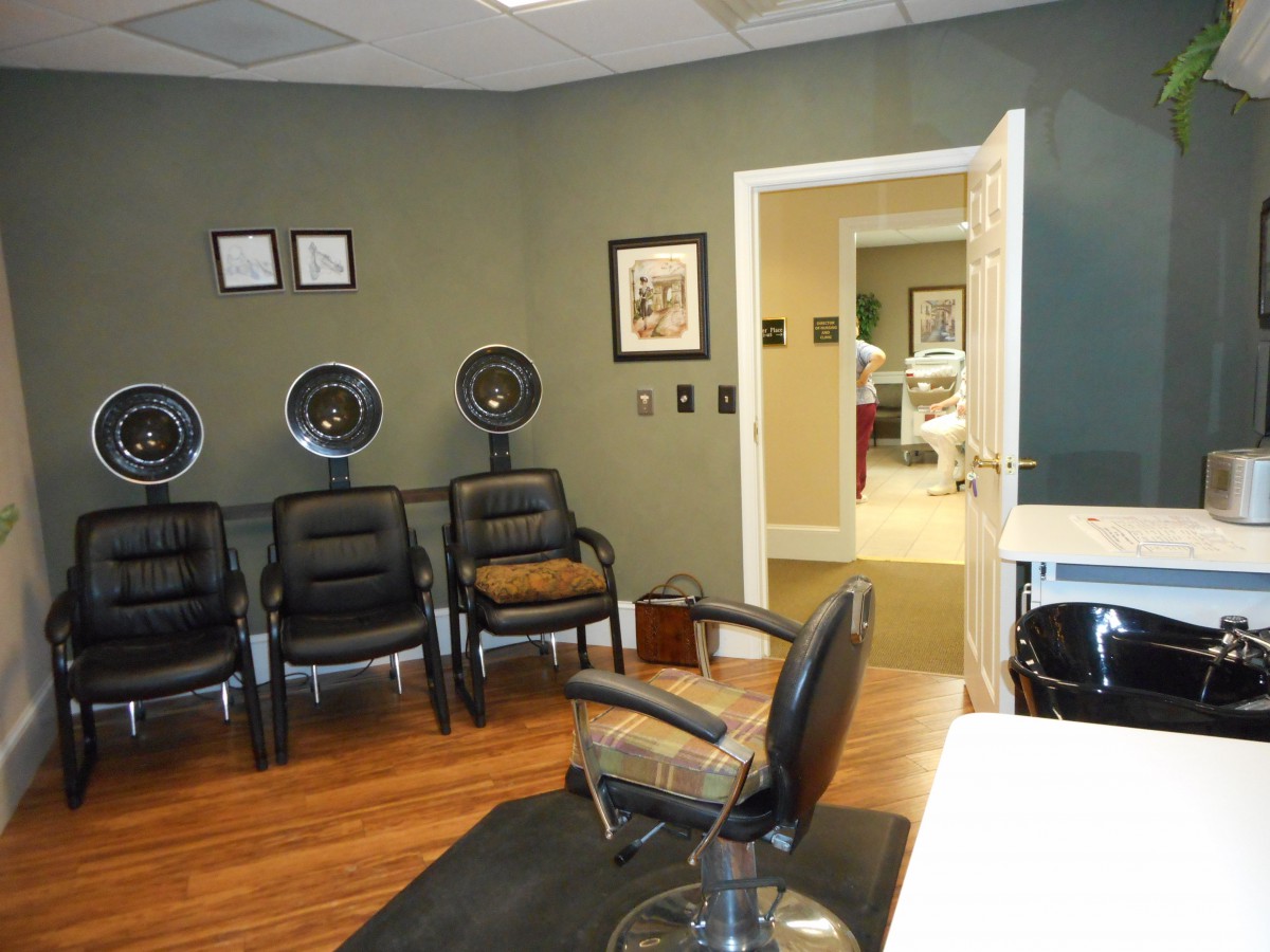 A salon waiting area with chairs and hair dryers.