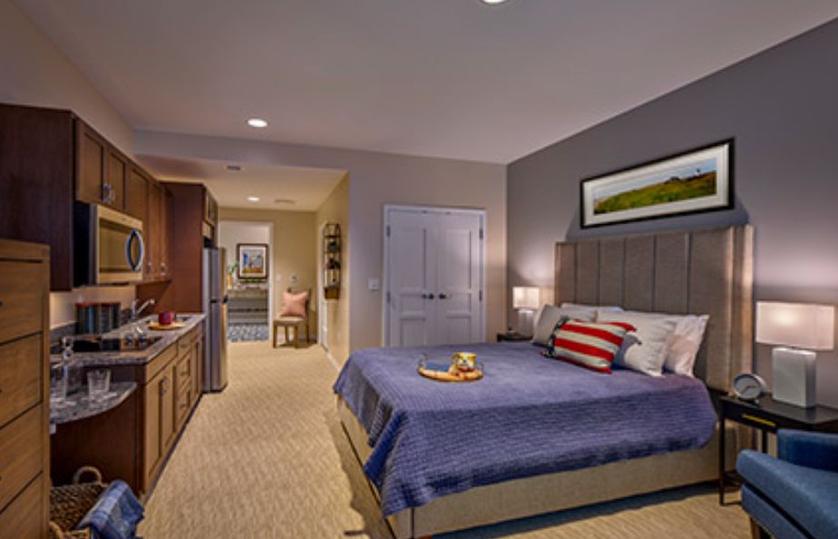 A modern and cozy bedroom interior with a neatly made bed, bedside lamps, and wall artwork.