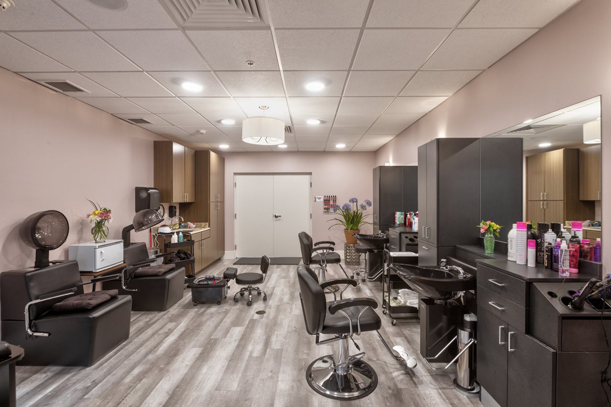 A modern hair salon interior with stylish chairs and mirrors, well-lit and organized for customer service.