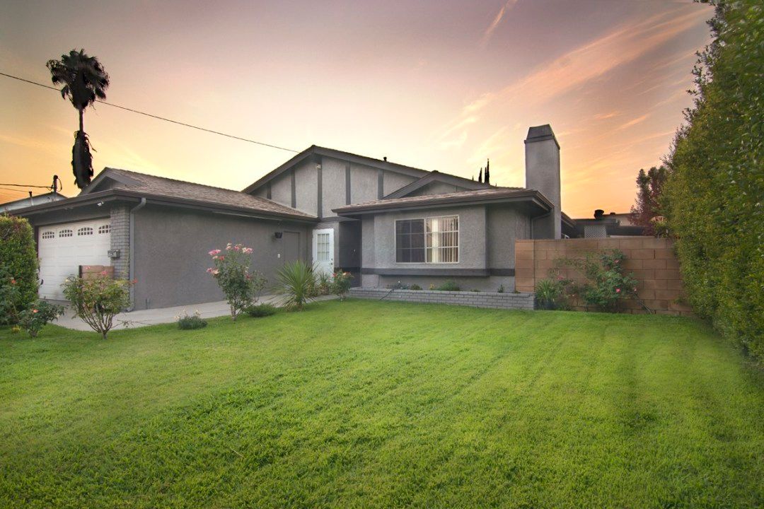 A cozy house with a well-maintained lawn during sunset.