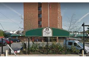 Entrance to a residential building with a green canopy and sign.