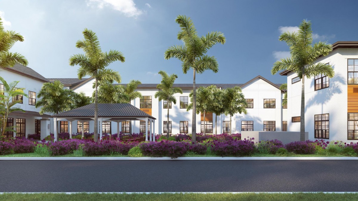 A modern residential building surrounded by palm trees and a landscaped garden.