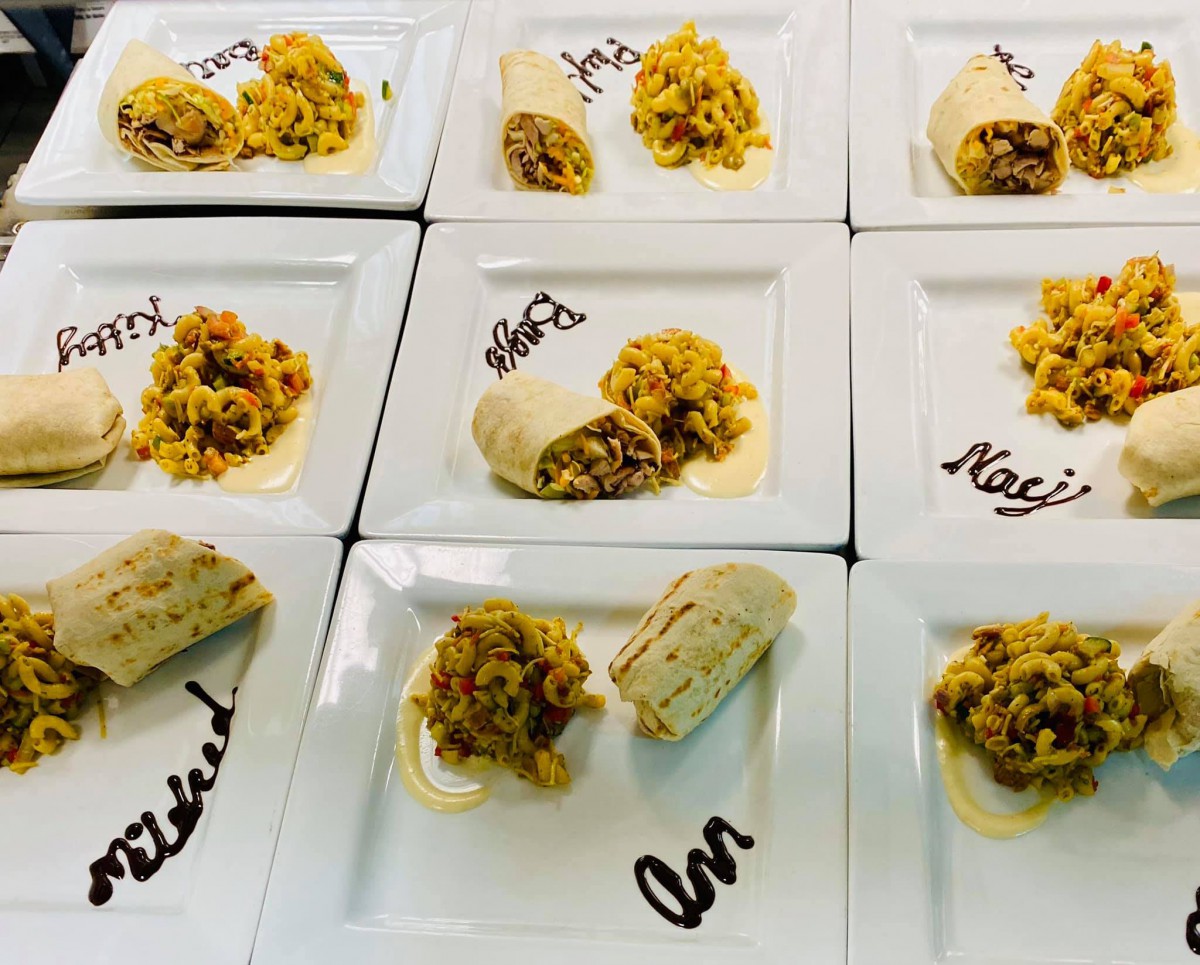 A gourmet presentation of plated tacos on several dishes, each labeled with different names.