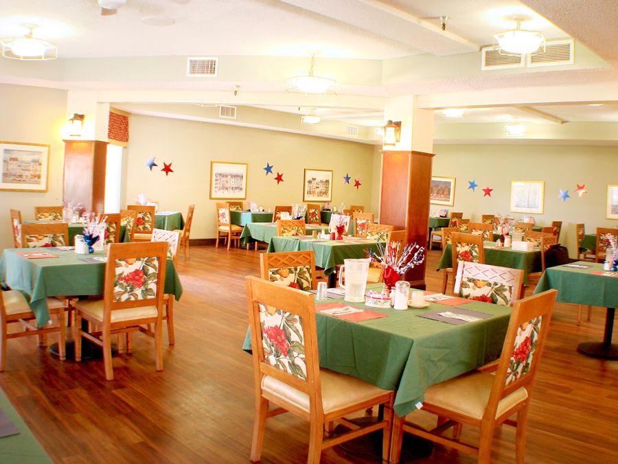 A spacious dining area with neatly arranged tables and chairs, adorned with decorative items.