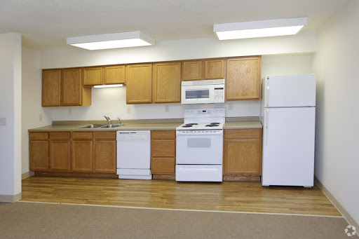 A modern kitchen featuring wooden cabinets, essential appliances, and a clean, organized layout.