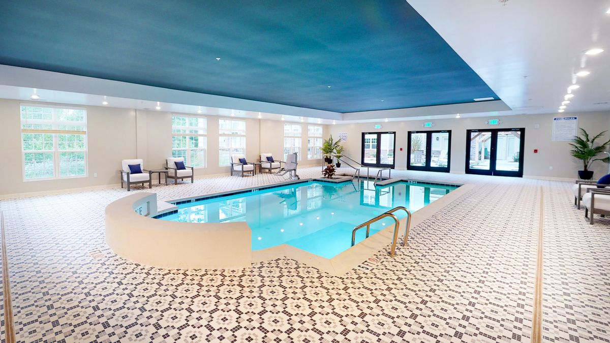A serene indoor swimming pool area with lounge chairs and modern decor.