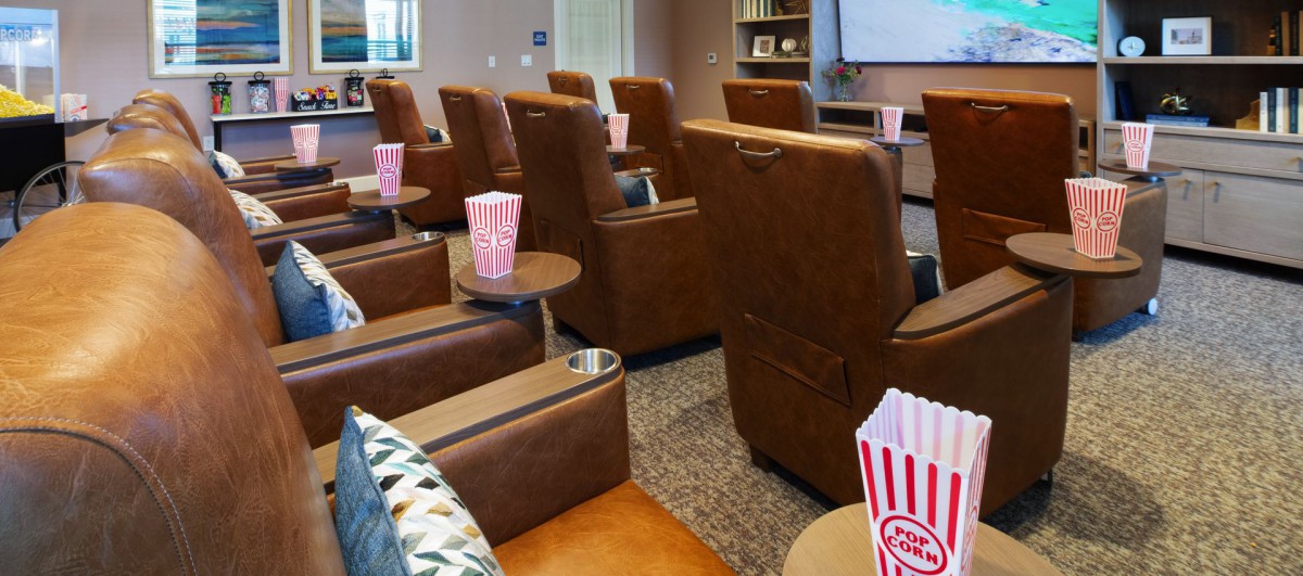 A cozy home theater with recliner chairs and popcorn ready for a movie night.