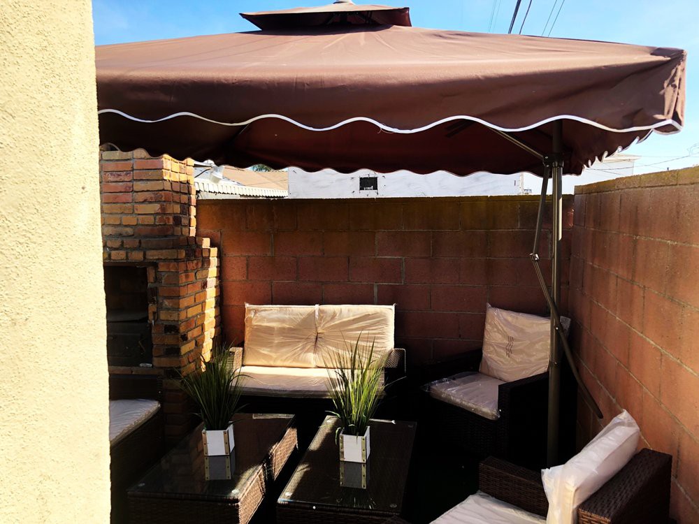 Cozy outdoor patio area with seating and a large umbrella.