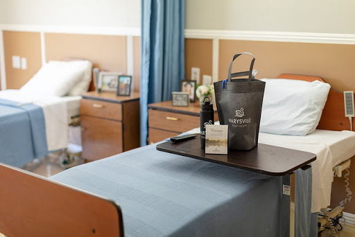 A cozy hospital room featuring a bedside tray with personal items and a clean, well-organized environment.