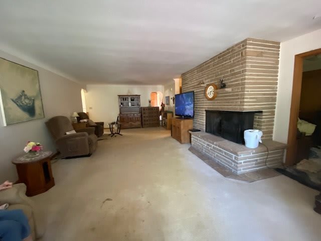 A spacious living room with a fireplace, television, and comfortable seating.