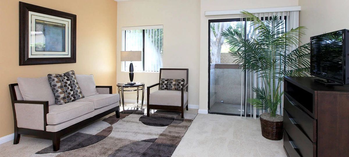 A modern living room with a sofa, armchair, and elegant decor.