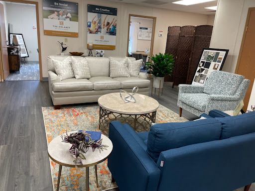 A cozy living room setup featuring a light beige sofa, blue armchairs, and a stylish coffee table.
