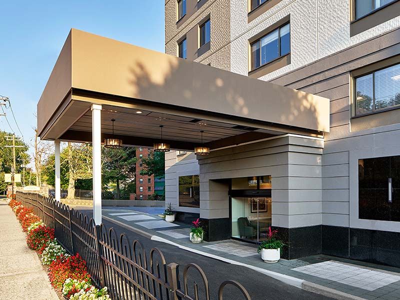 A hotel entrance with a canopy and well-maintained landscaping.