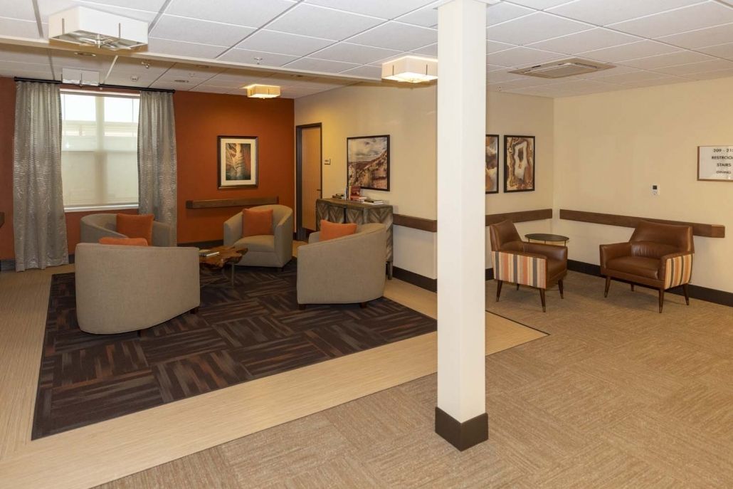 A cozy lounge area with comfortable seating and artwork on the walls.
