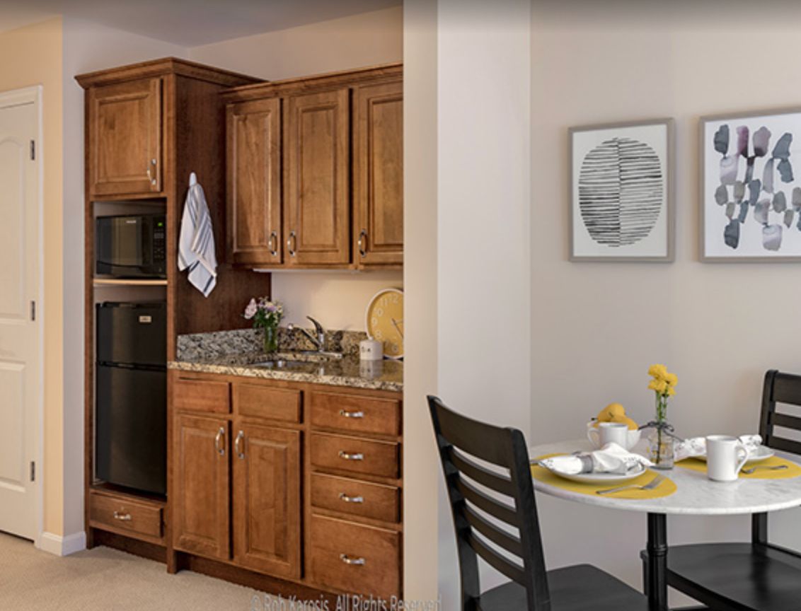 A modern kitchen with wooden cabinets and a cozy dining area.