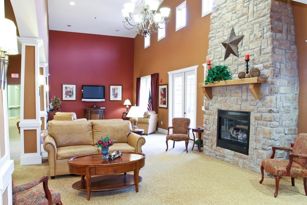 A cozy living room with a stone fireplace, comfortable seating, and elegant decor.