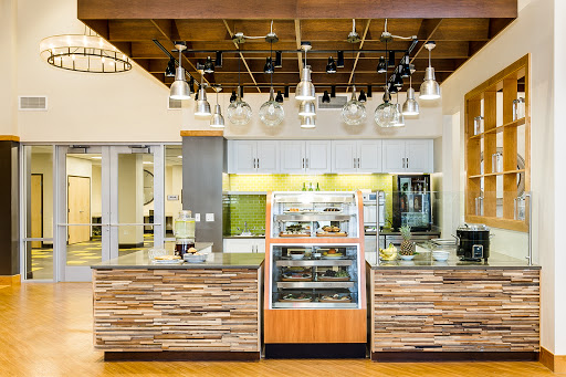 A stylish and modern cafe interior featuring a wooden counter and a bakery display.