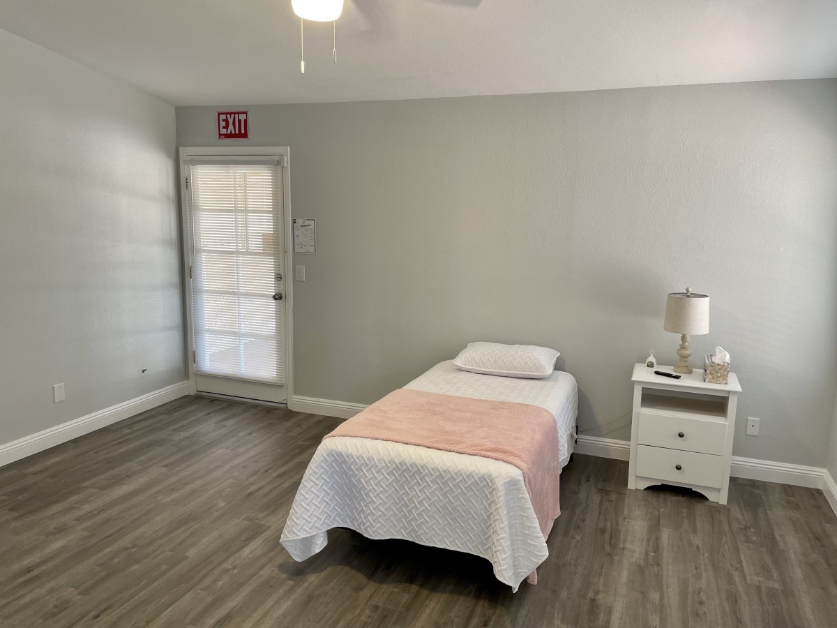 A minimalist bedroom with a single bed and simple decor.