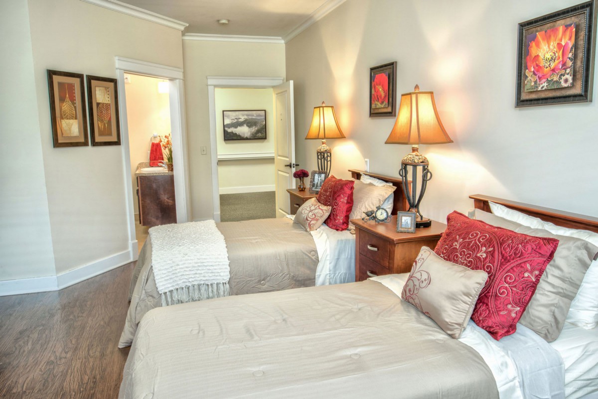 A cozy bedroom with twin beds, neutral tones, and decorative pillows.