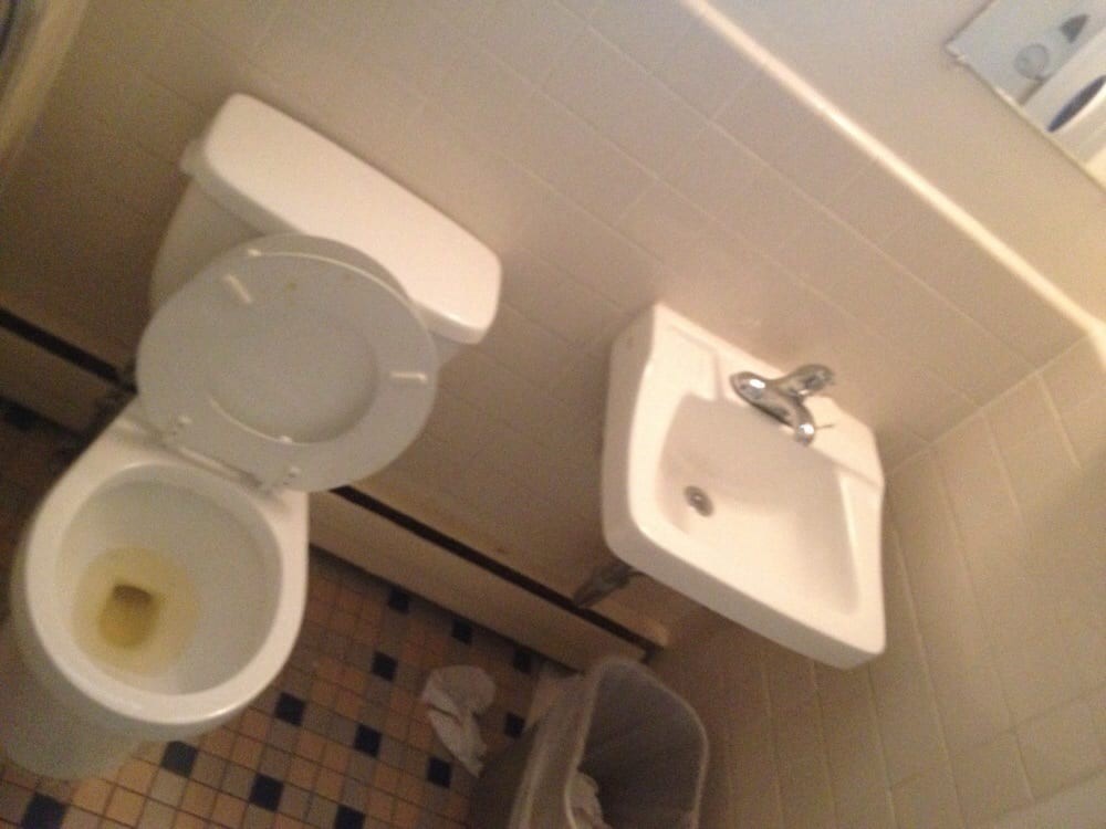A small bathroom featuring a toilet, sink, and tiled floor.