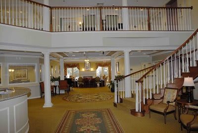 A spacious lobby interior with a staircase and balcony.