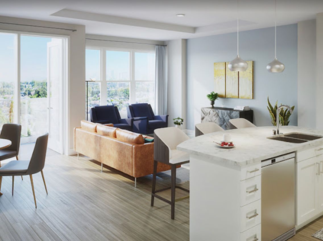A modern open-plan living room and kitchen with ample natural light.
