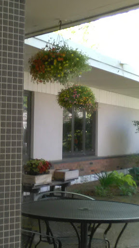 A serene outdoor space featuring lush hanging planters and a stylish building facade.