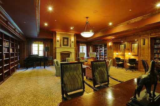 A cozy and elegant office space with brown tones, featuring a fireplace and comfortable seating.