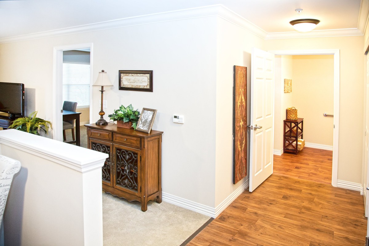 A cozy home hallway featuring a wooden sideboard adorned with decor items and artwork on the walls.