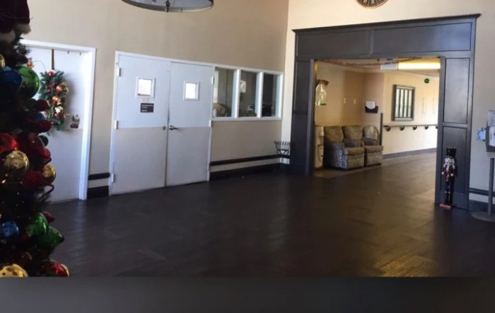 An empty lobby area with white doors and a small waiting area.
