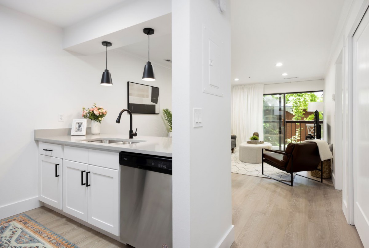A modern open-concept kitchen leading into a stylish living room with contemporary decor.