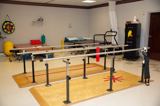 A well-equipped physical therapy room featuring parallel bars for rehabilitation exercises.