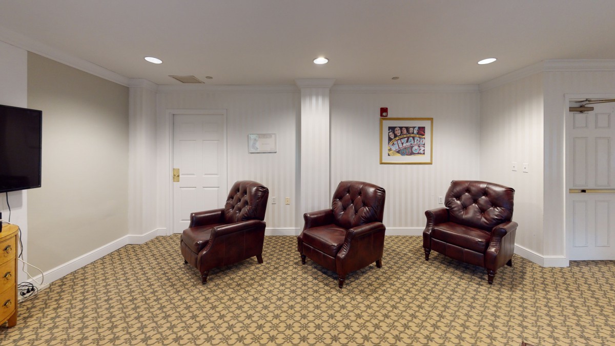 A cozy waiting room with leather chairs and a patterned carpet.