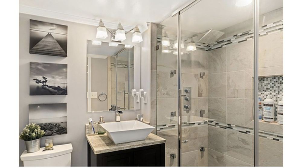 A modern bathroom with a glass-enclosed shower and stylish fixtures.