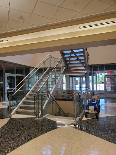 A modern lobby featuring a glass staircase and open design elements.