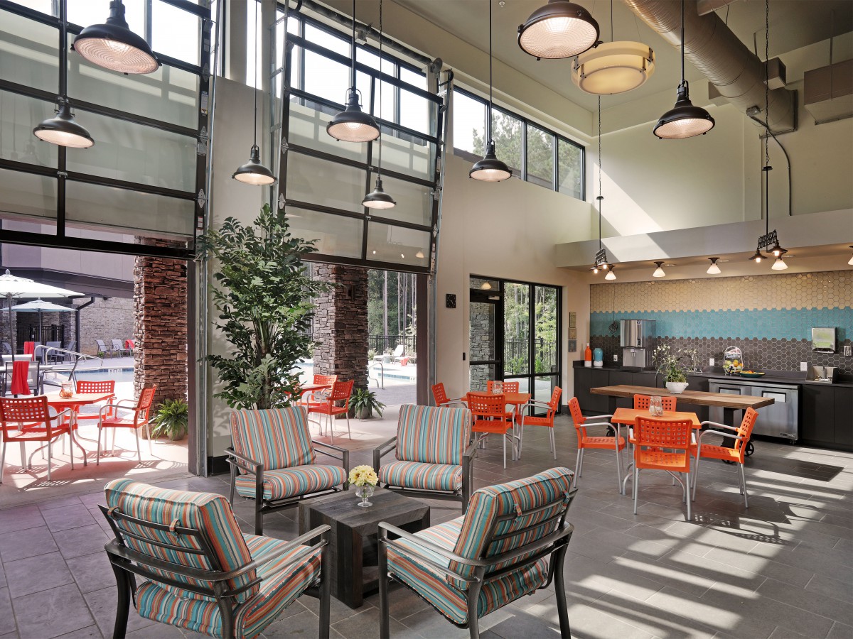 A modern lounge area with comfortable seating and ample natural light streaming through large windows.