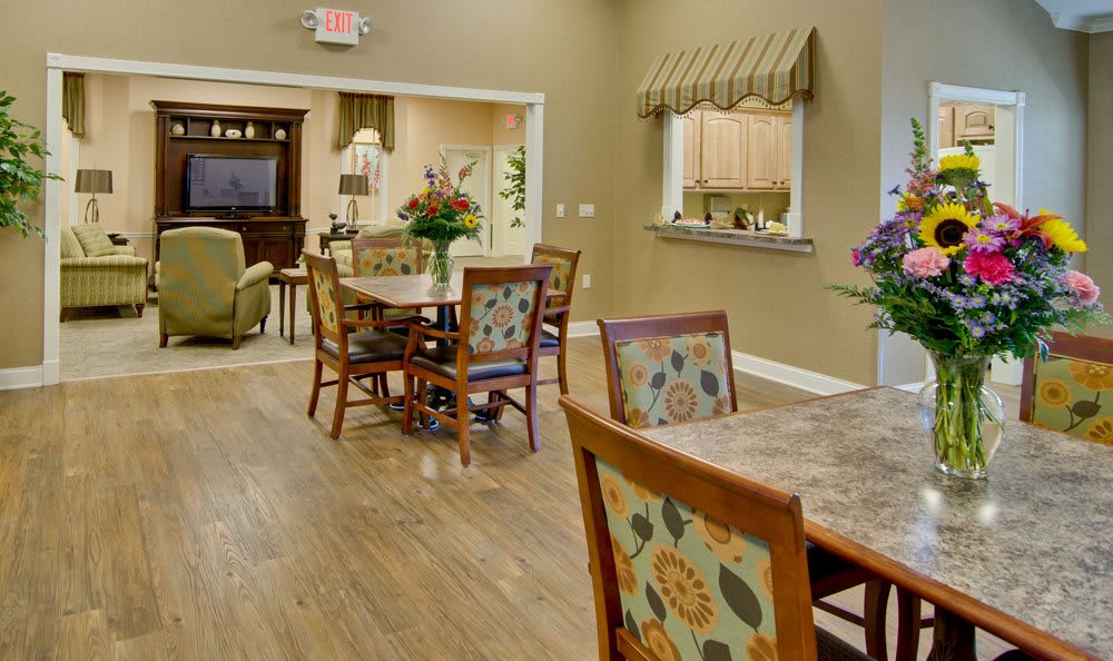 A cozy dining area with floral patterned chairs and wooden floors.