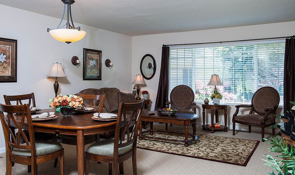 A cozy, traditional-style living and dining area with warm wood furniture and soft lighting.