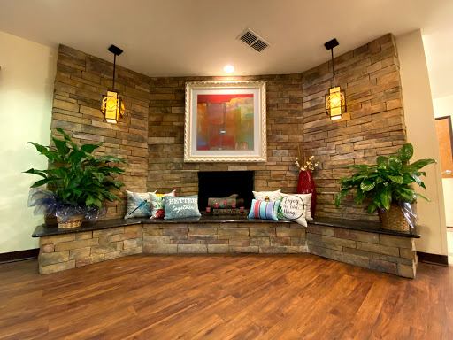 A cozy living room corner featuring a stone wall, decorative lighting, and a welcoming fireplace.