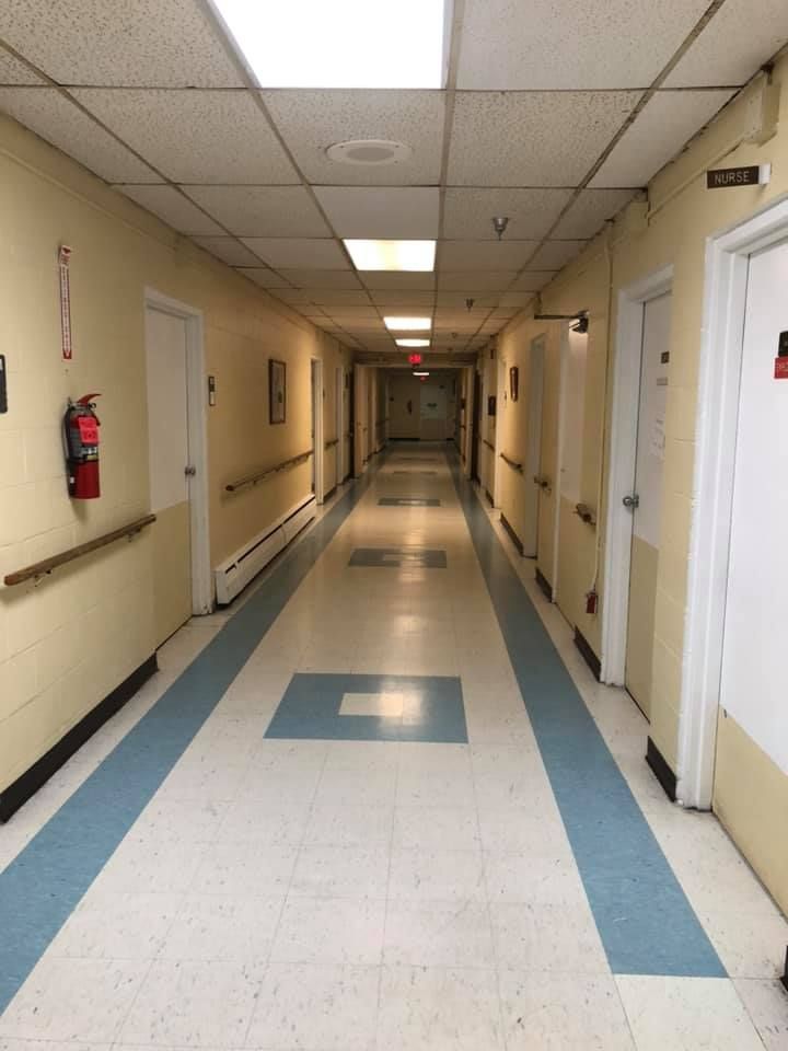 A long hospital corridor with doors on both sides.