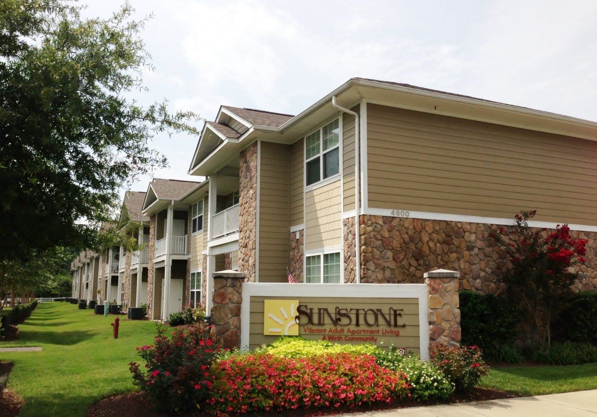 Exterior view of a residential apartment complex with landscaped surroundings.