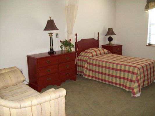 A cozy bedroom with twin beds, wooden furniture, and plaid bedspreads.