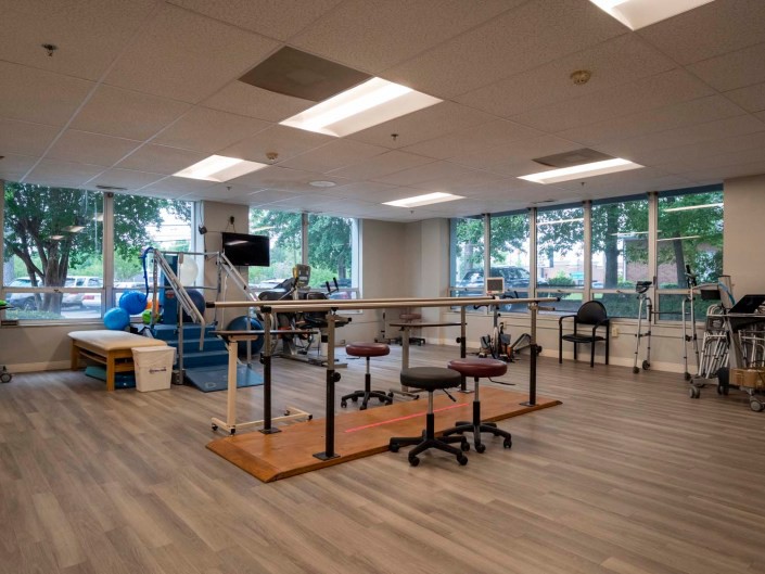 A spacious physical therapy room equipped with rehabilitation equipment and exercise tools.