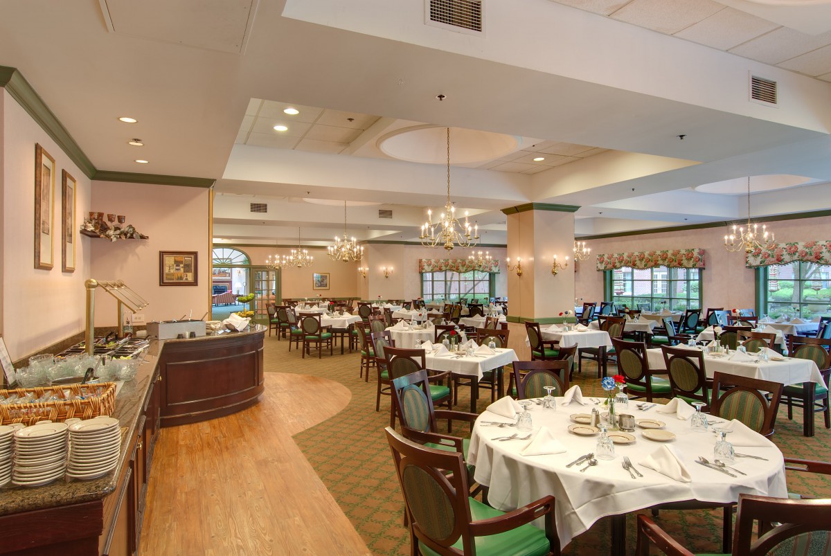 An elegant and spacious restaurant dining room with neatly arranged tables and chairs.