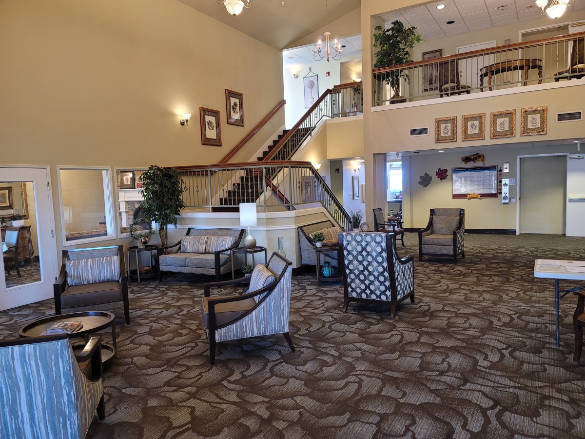A spacious hotel lobby with comfortable seating and a staircase.