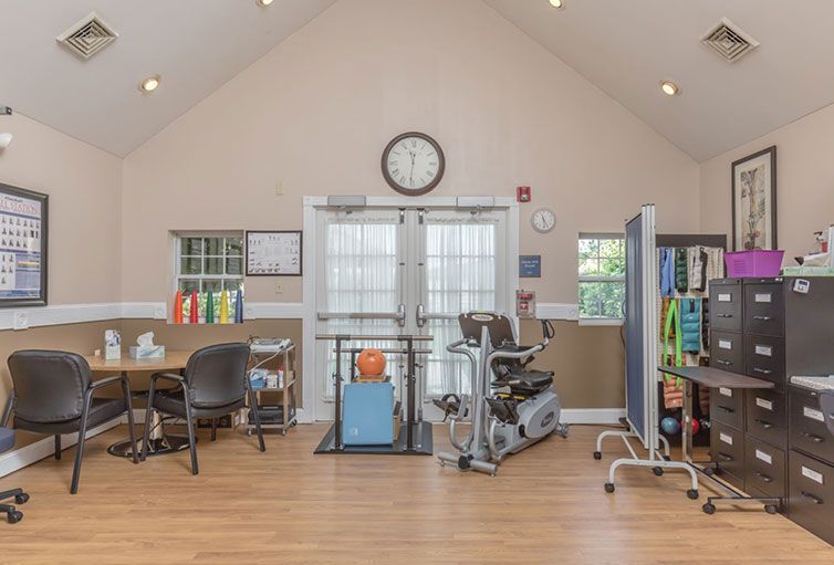 A rehabilitation clinic with exercise equipment and desks for physical therapy sessions.